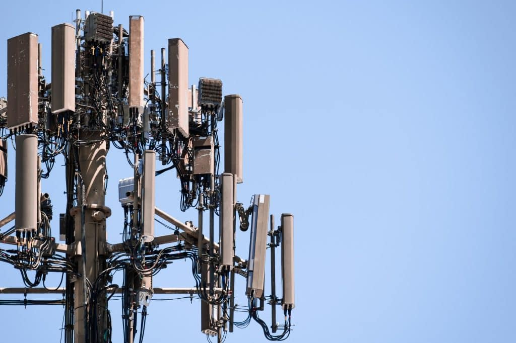 Close-up of cell tower antenna equipment against a clear blue sky